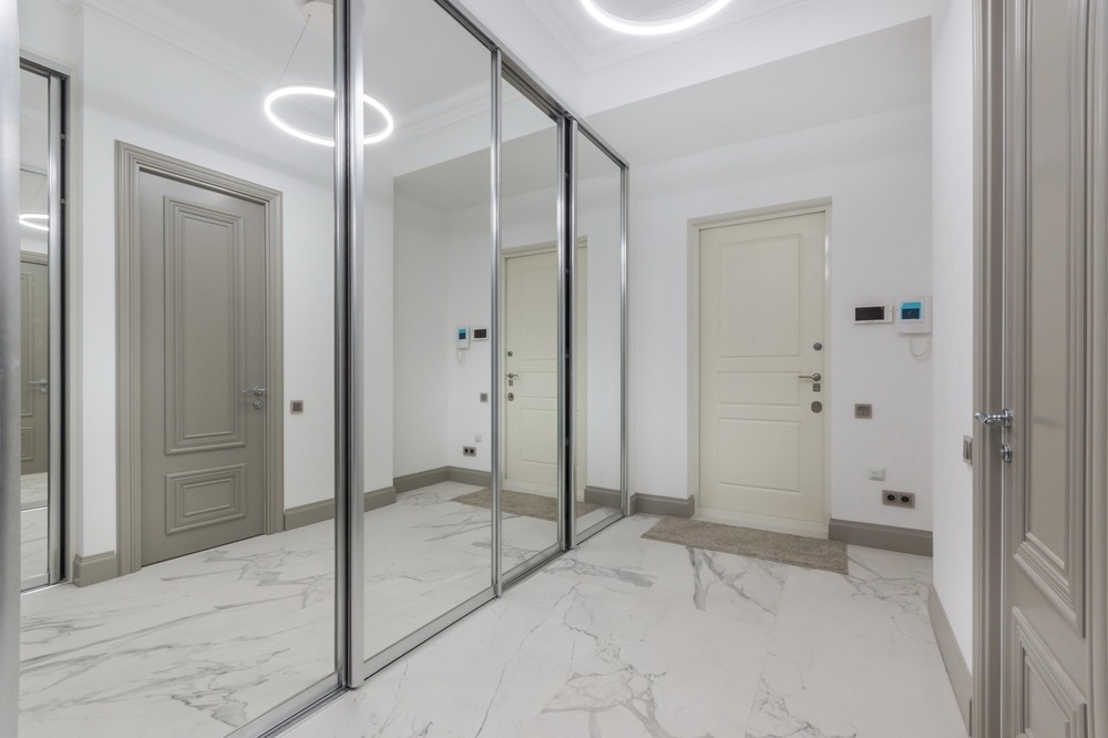 Montáž posuvných dverí so zrkadlom na chodbe.